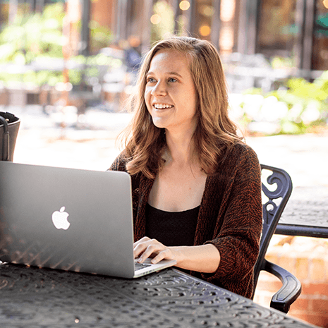 woman sitting outside using laptop