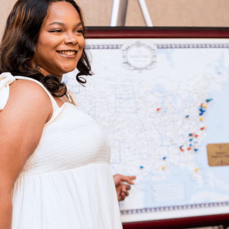 student in front of map with pins