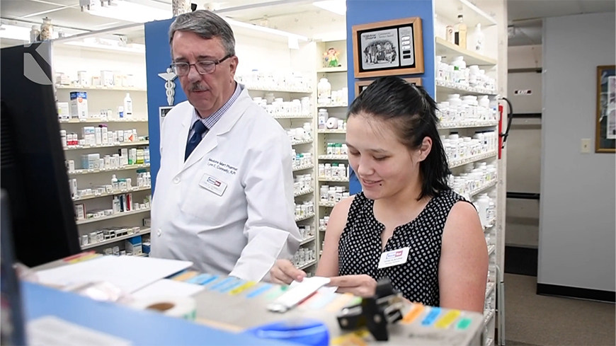 Two pharmacists working at a computer