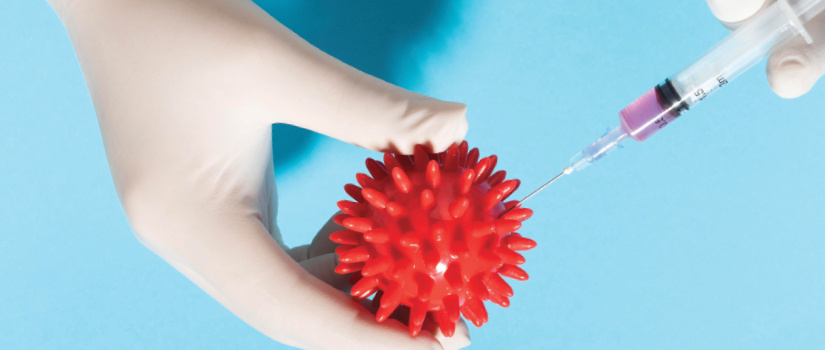 Hands injecting a shot into a rubber ball
