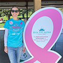 Alumna with a breast cancer ribbon sign