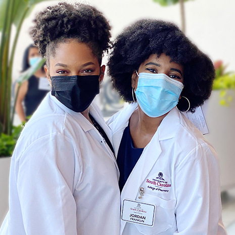 Two female students in white lab coats