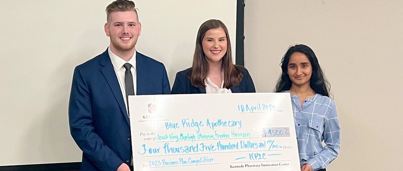 Students holding a large check