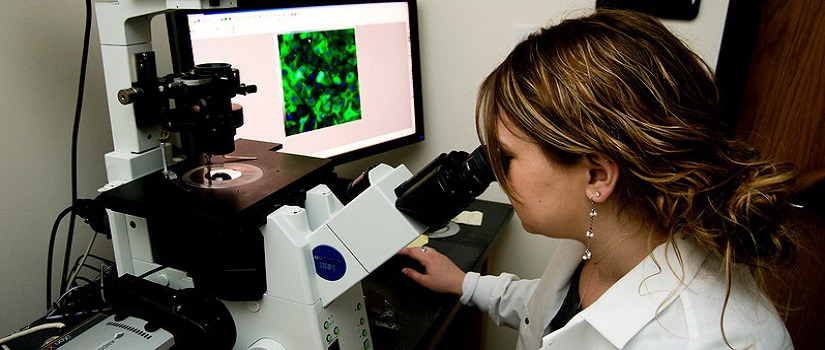 Woman looking into a microscope