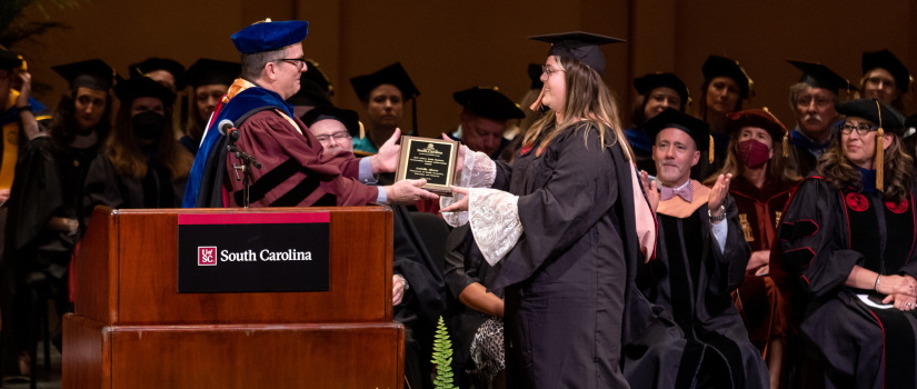 A graduate receives an award for achievement