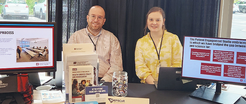 A faculty member and student sitting at table at a recruitment fair
