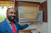 Associate Professor Shaun Owens opens the pull out cabinets in the kitchen.