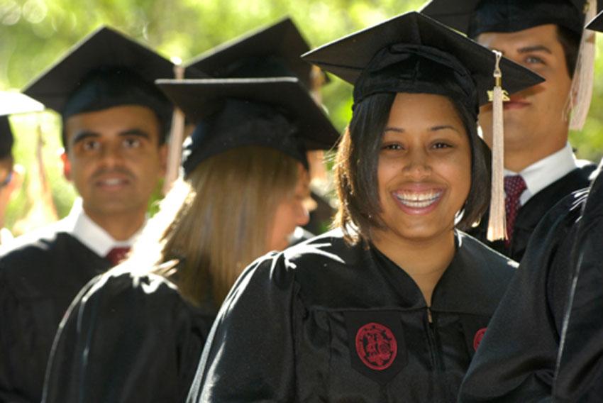 Image of students in their caps and gowns at graduation.