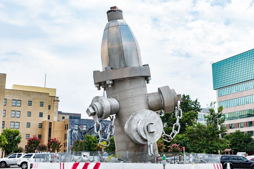 "Busted Plug" by Blue Sky is four stories in tall and weighs 675,000 pounds, making it the world's largest fire hydrant. The colossal sculpture is located on Taylor Street, between Marion Street and Bull Street. Photo by Crush Rush.