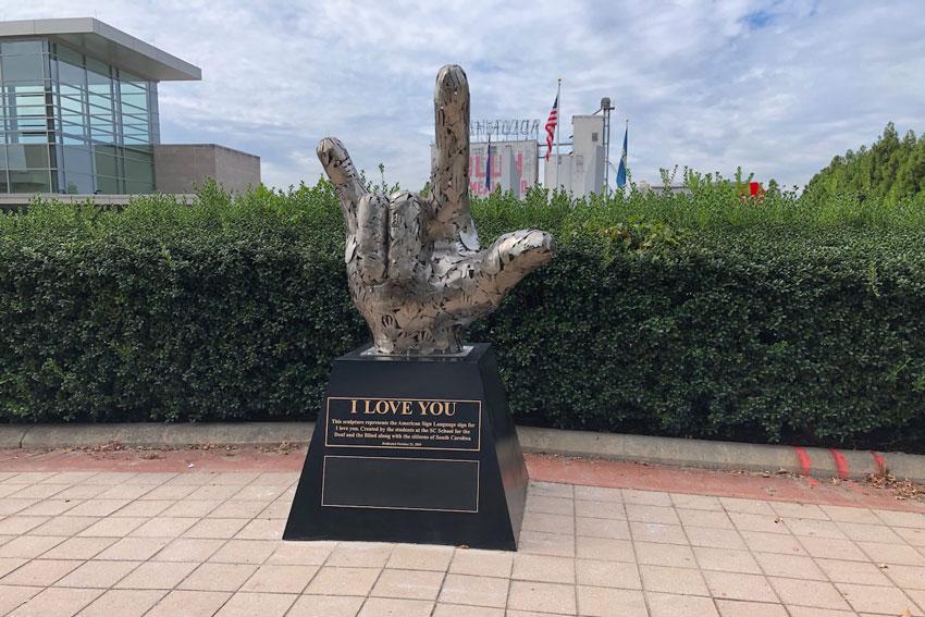 "I Love You" by Bob Doster was donated to the City of Columbia by the SC School for the Deaf and Blind Foundation in 2019. According to the One Columbia public art directory, "The sculpture, a 4-foot tall hand forming the American Sign Language sign for 'I love you,' is made of a series of hand shapes that were created by students working with Doster to trace their hands on steel sheets that were then cut and patched together to create the sculptural shape." Photo by One Columbia.
