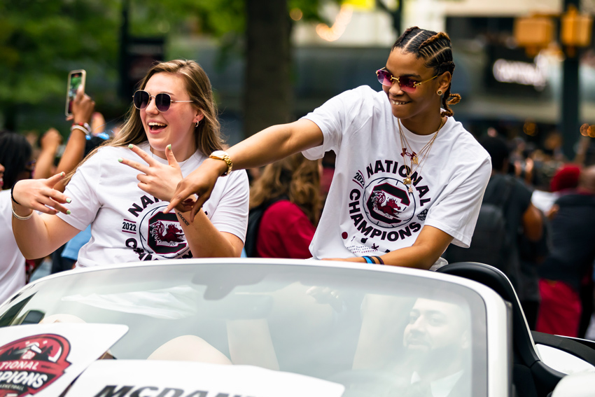 Elysa Wesolek and Lele Grissett ride in a convertible during the 2022 championship parade. 