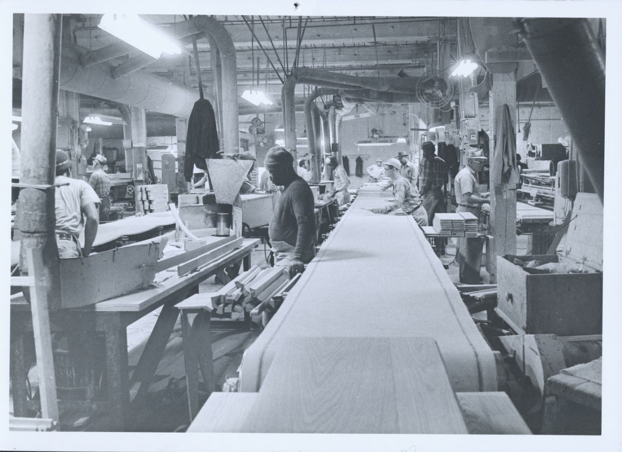 The workshop included a conveyer belt manned on either side by workers.