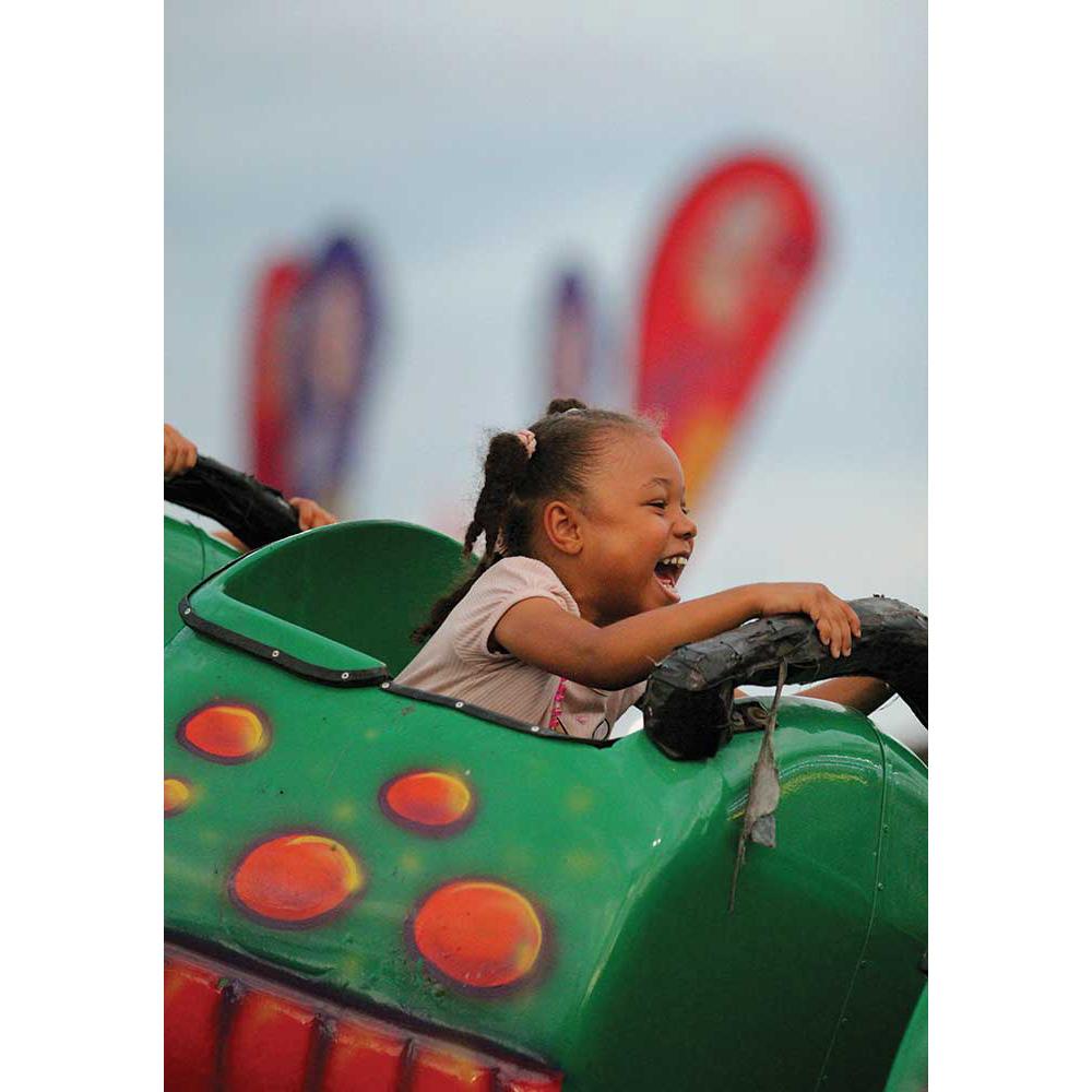 A young African American girl rides a roller coaster at the SC State Fair.