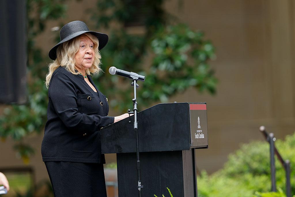 Treadwell stands at the lectern at the monument unveiling and speaks to a crowd.