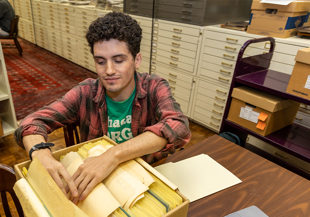 Stevie Malenowski combs through a box of papers and images in Thomas Cooper Library.