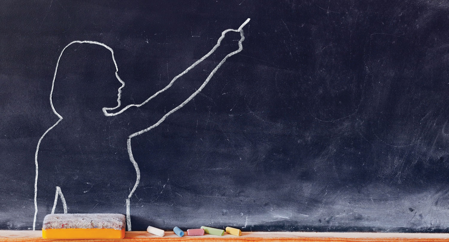 An outline of a teacher in chalk on a blackboard.