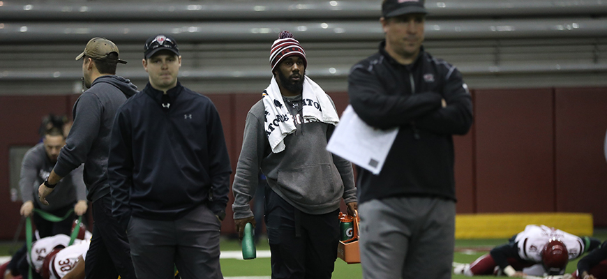 Ronald Parker works with football team during practice