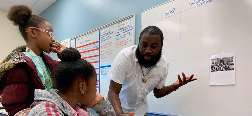 Gibson works with students in his fifth grade class