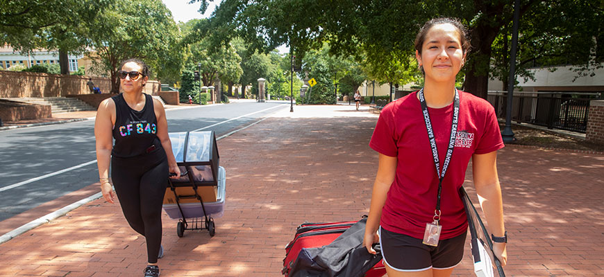 New students haul their thin along Greene Street as they move in