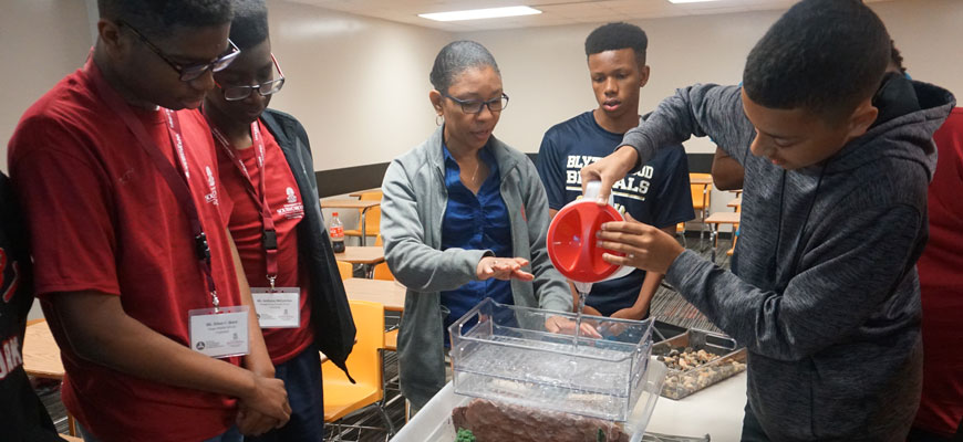 teacher and students perform an experiment at summer camp