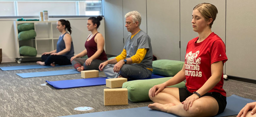 People practicing yoga at the calm oasis space at the health center