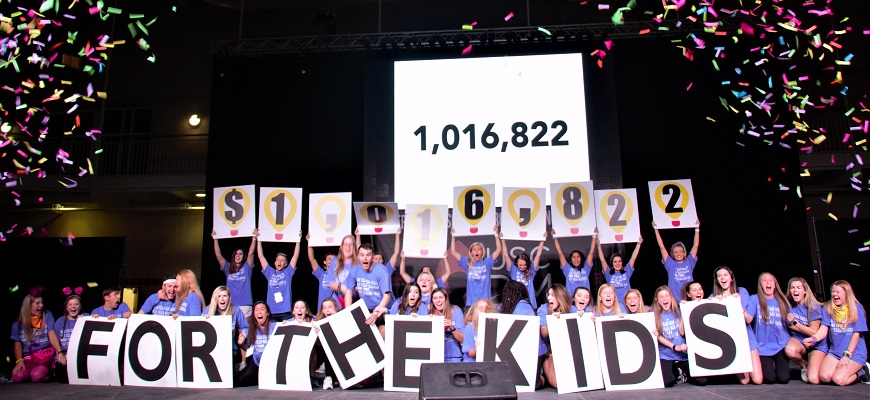 members of the USCDM student organization holding posters revealing they raised $1016822 