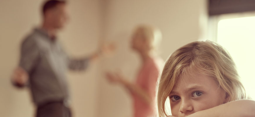 child with parents arguing in the background