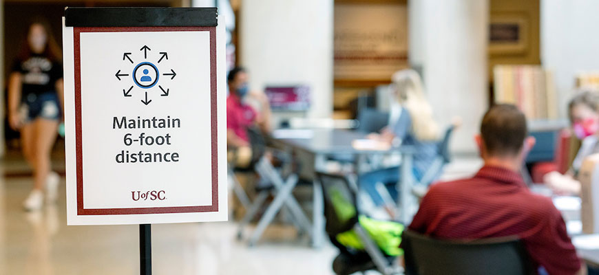 Maintain six-foot distance sign in front of tables and chairs in Russell House