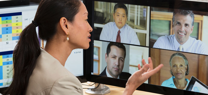 woman in front of computer screen videoconferencing with co-workers