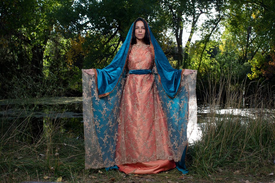 Film character Lady of Guadalupe in pink and lace dress and blue shawl over her head