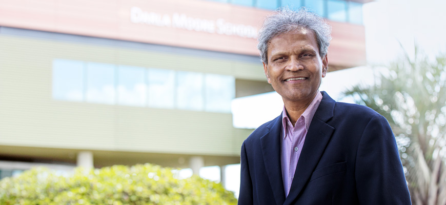Sanjay Ahire smiles for the camera with Darla Moore School of Business in the background