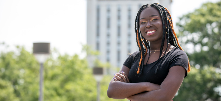 Fatou Diedhiou smiles with Capstone House in the background