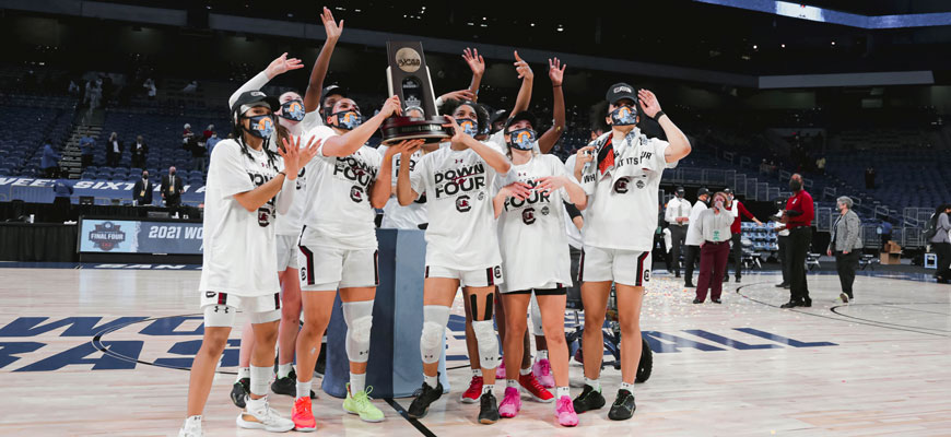 gamecocks women's basketball team hold a trophy and celebrate making the final four in 2021