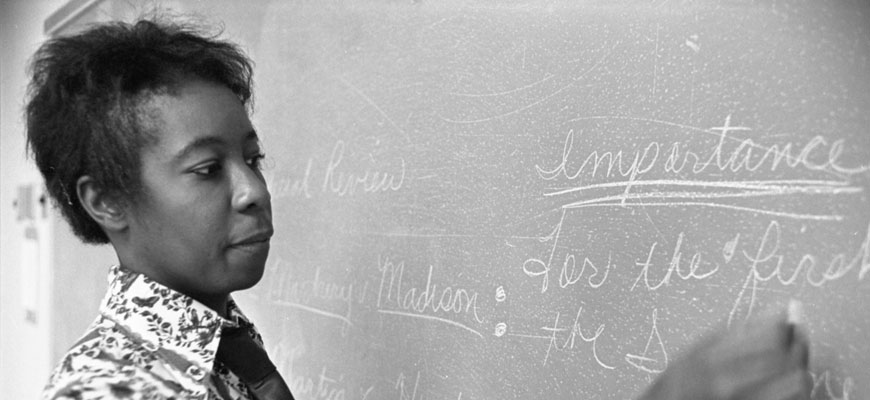 Edna Smith Primus writes on chalkboard; black & white photo, courtesy of Richland Library