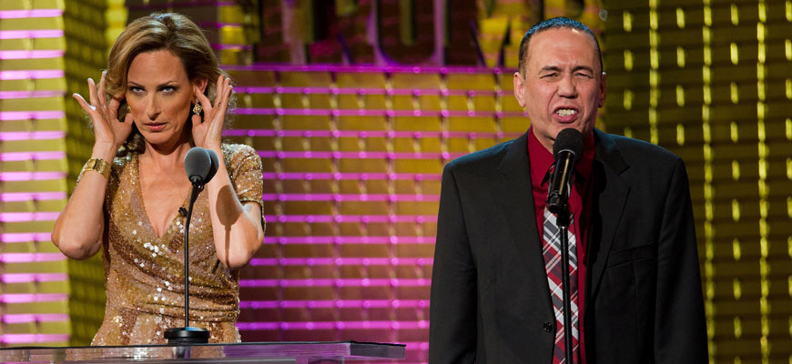 Gilbert Gottfried speaks into microphones and while actress Marlee Matlin covers her ears