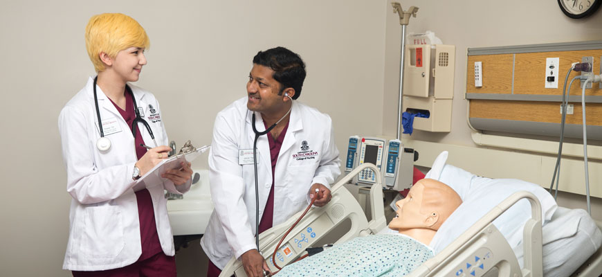 nursing students work with mannequin in the simulation lab