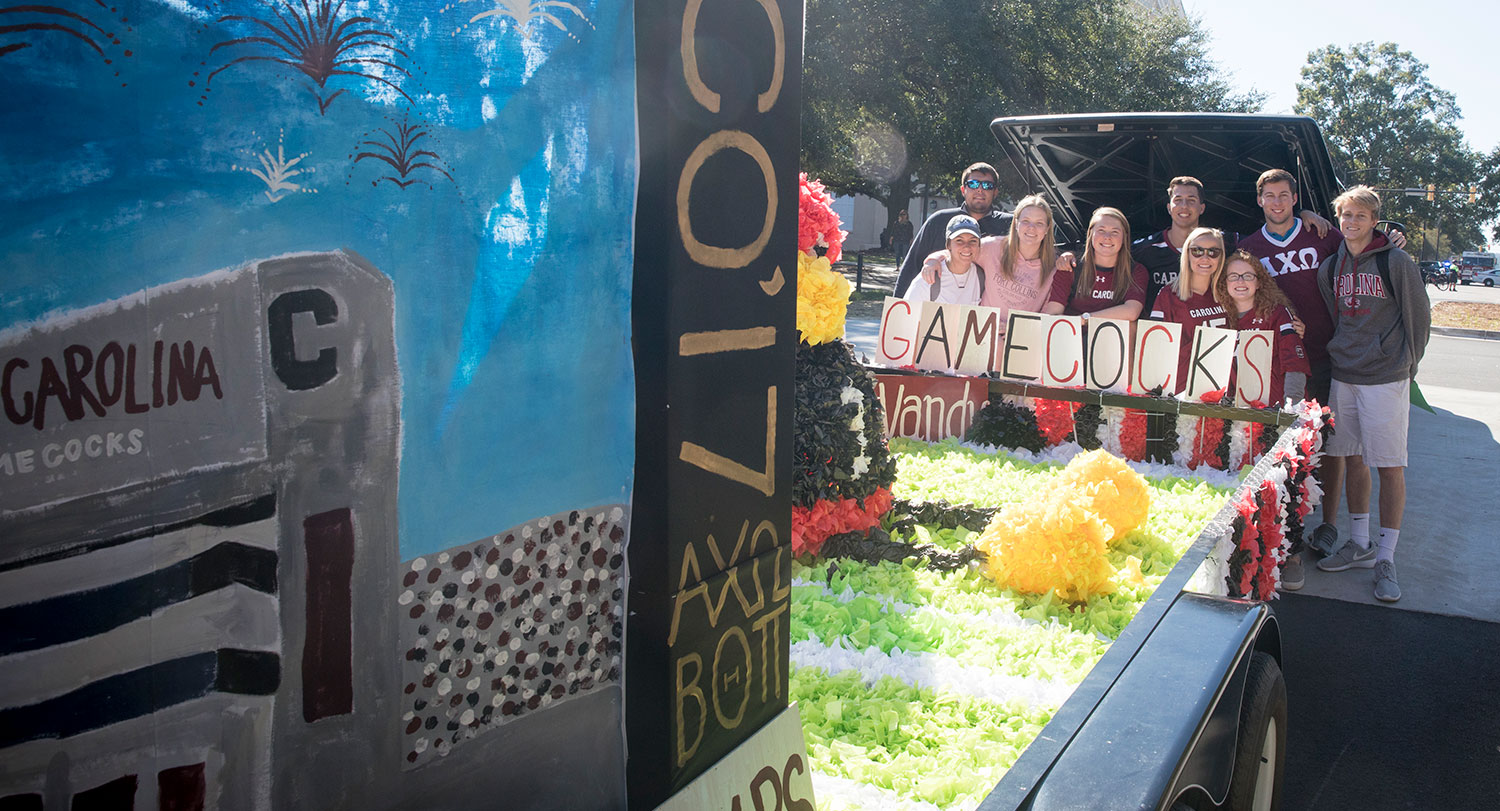 Students stand near a homecoming float.