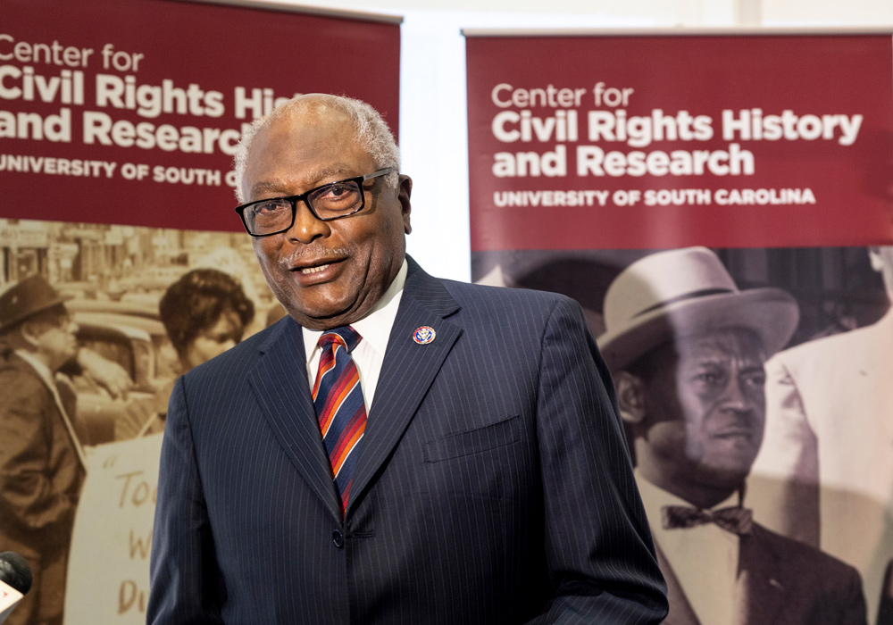 James Clyburn speaks to the media against a backdrop that says "Center for Civil Rights History and Research University of South Carolina"