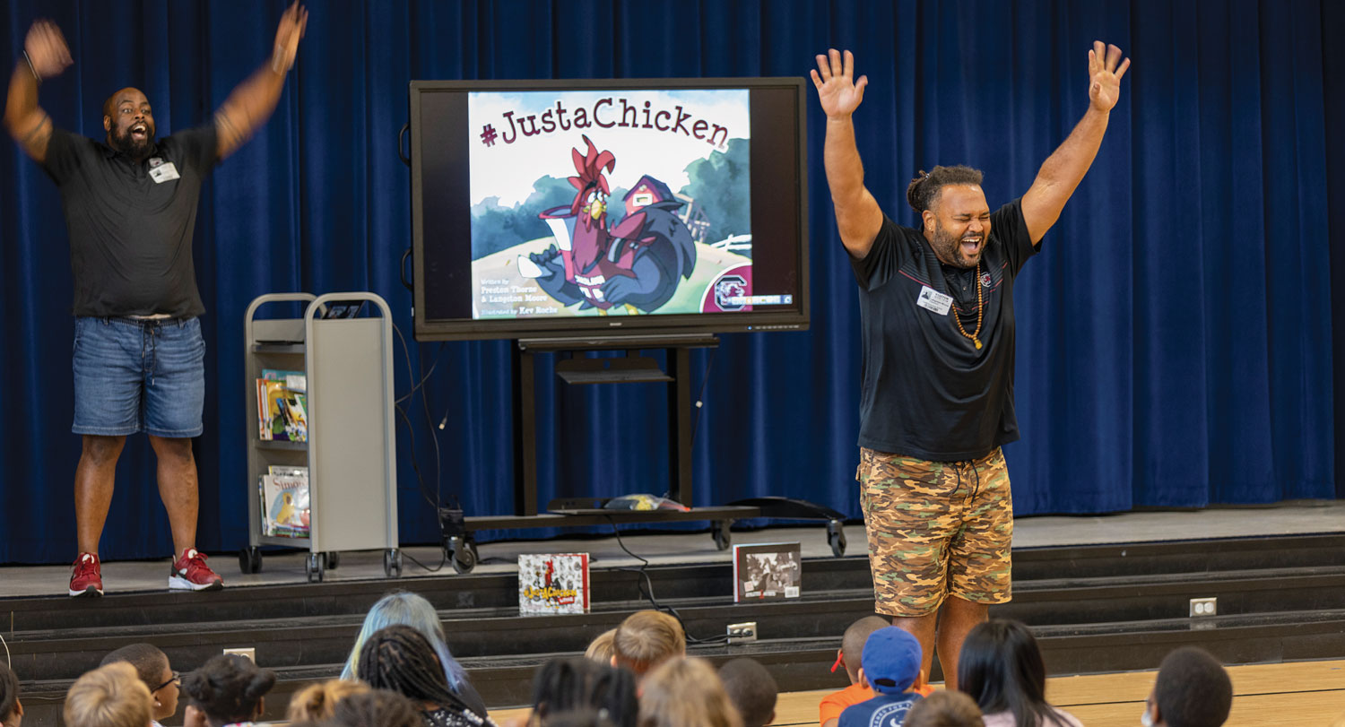 Preston Thorne (left) and Langston Moore get the kids pumped up for reading during an assembly at Lugoff Elementary in September.