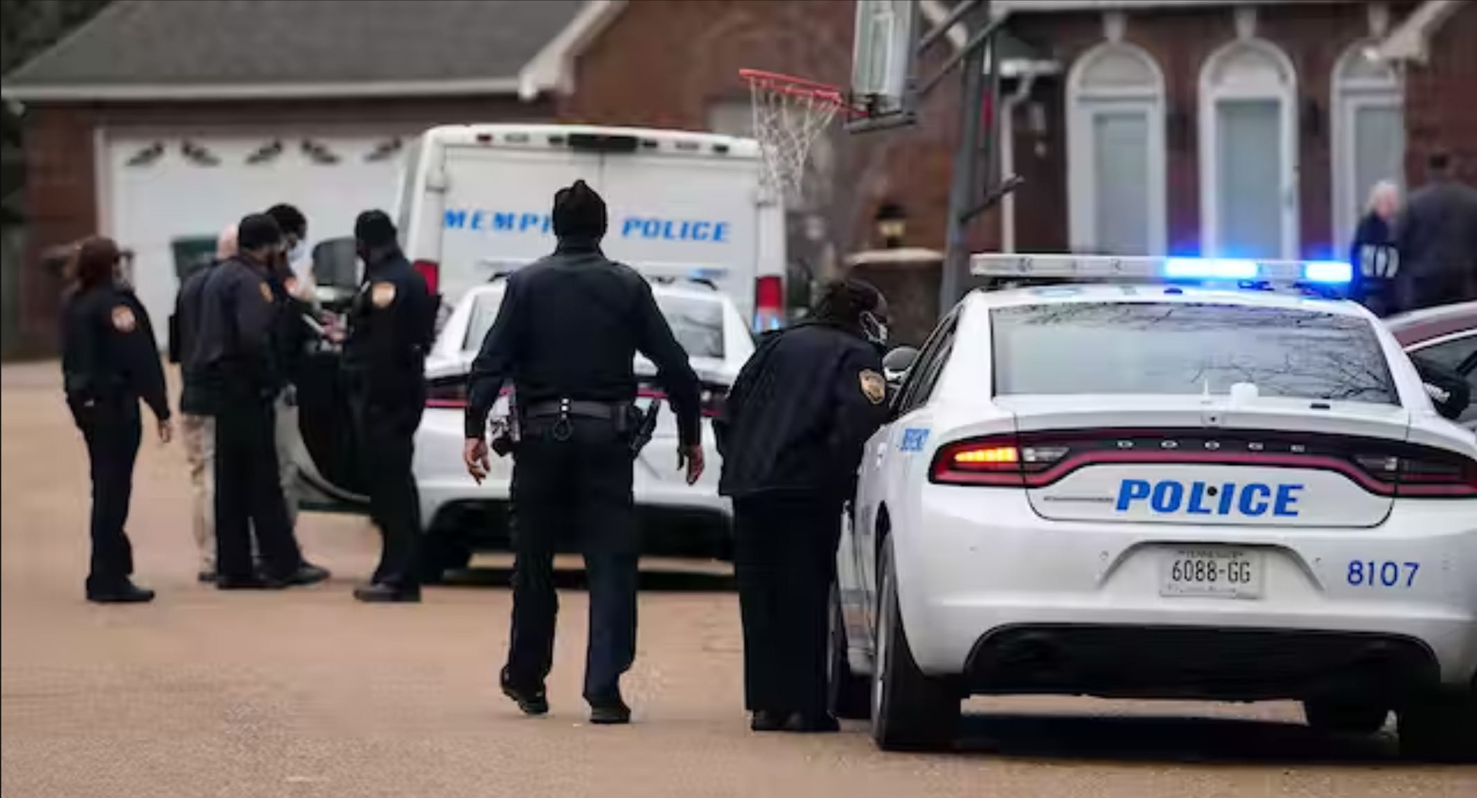 Several Memphis police officers stand next to police vehicles