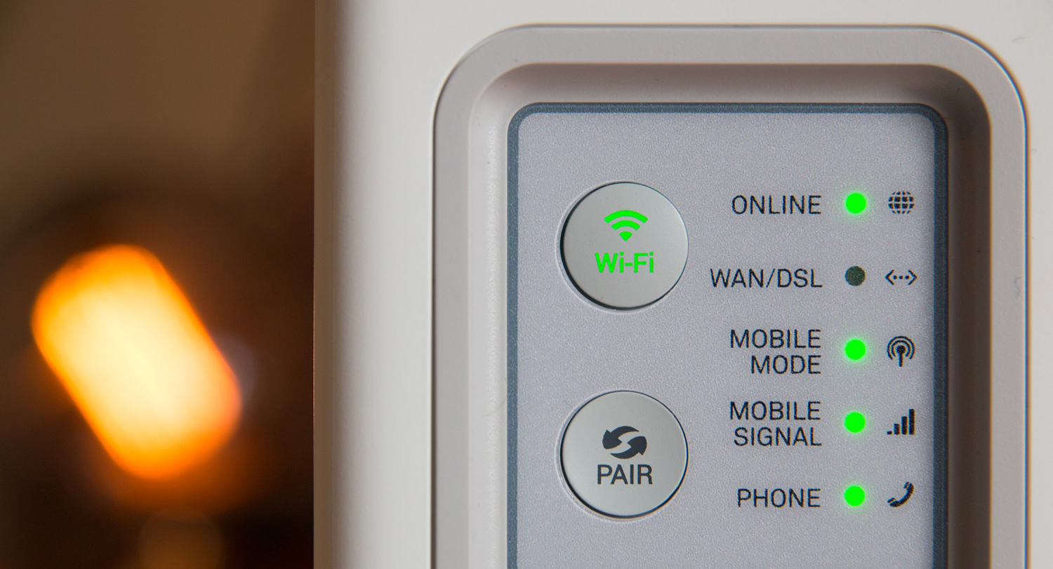 A green wifi symbol lights up on a wifi router.