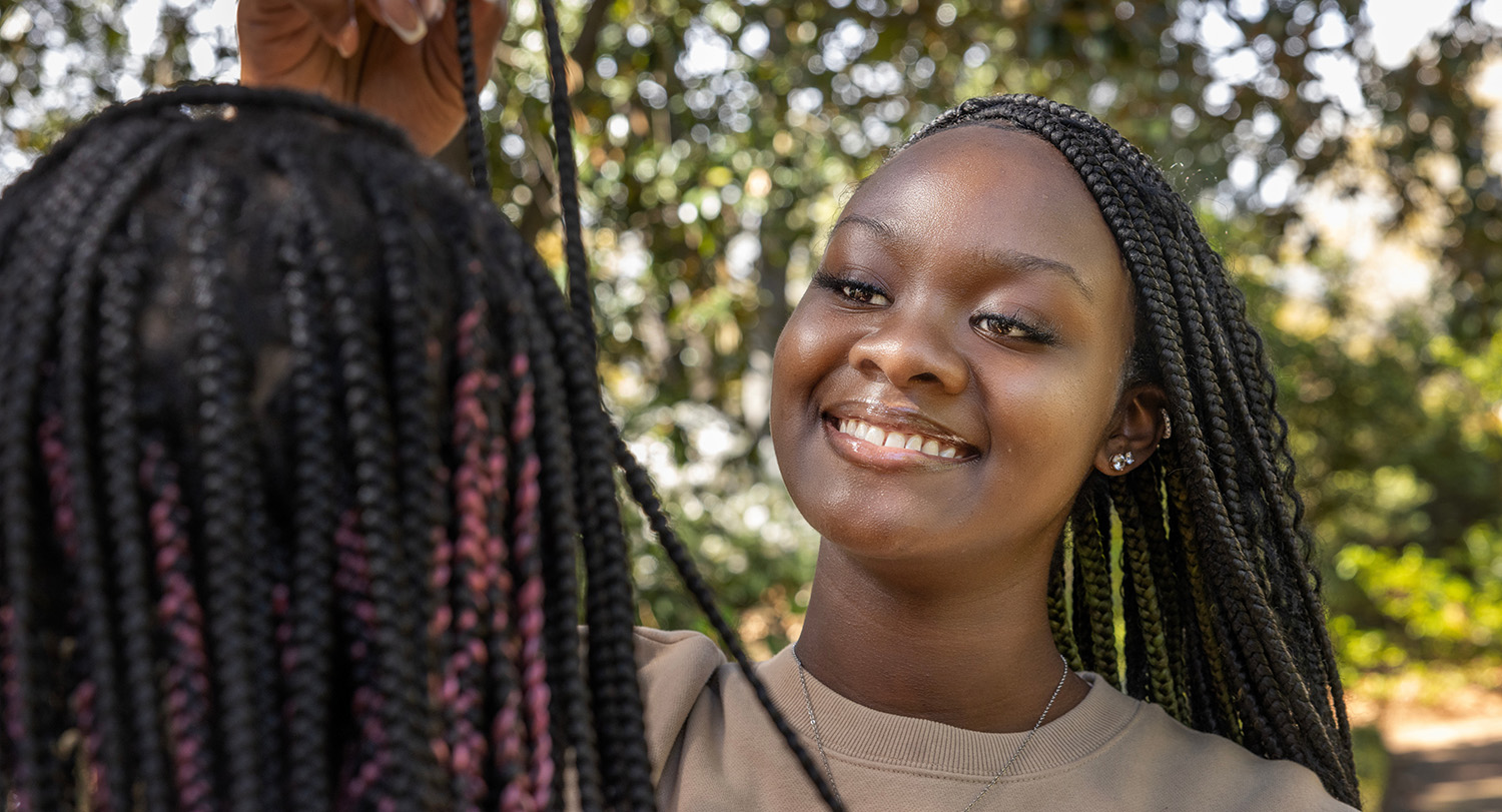 Jala Lewis assesses a client’s hair.