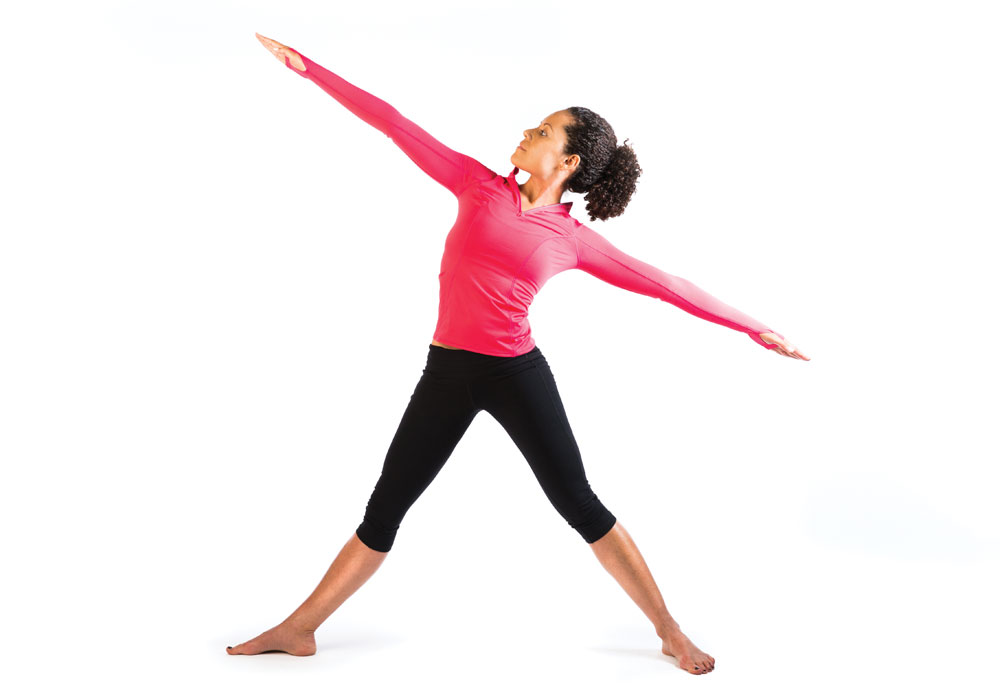 A woman with outstretched arms doing yoga.
