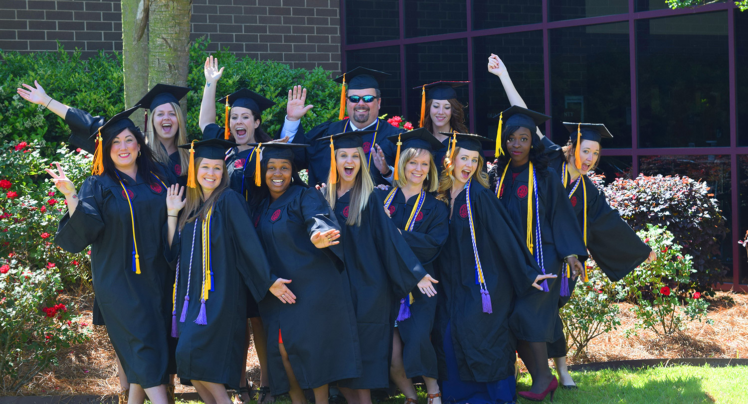 Students posing in caps and gowns.