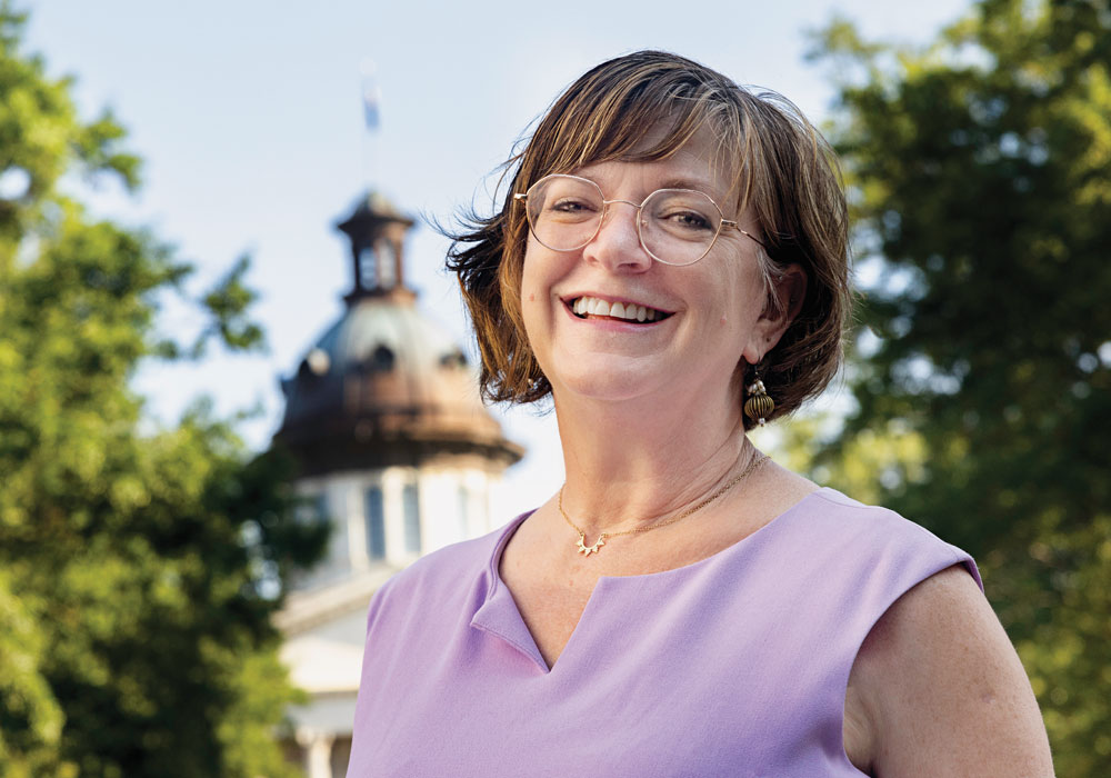 A portrait of Sara Barber with the SC Statehouse in the background.