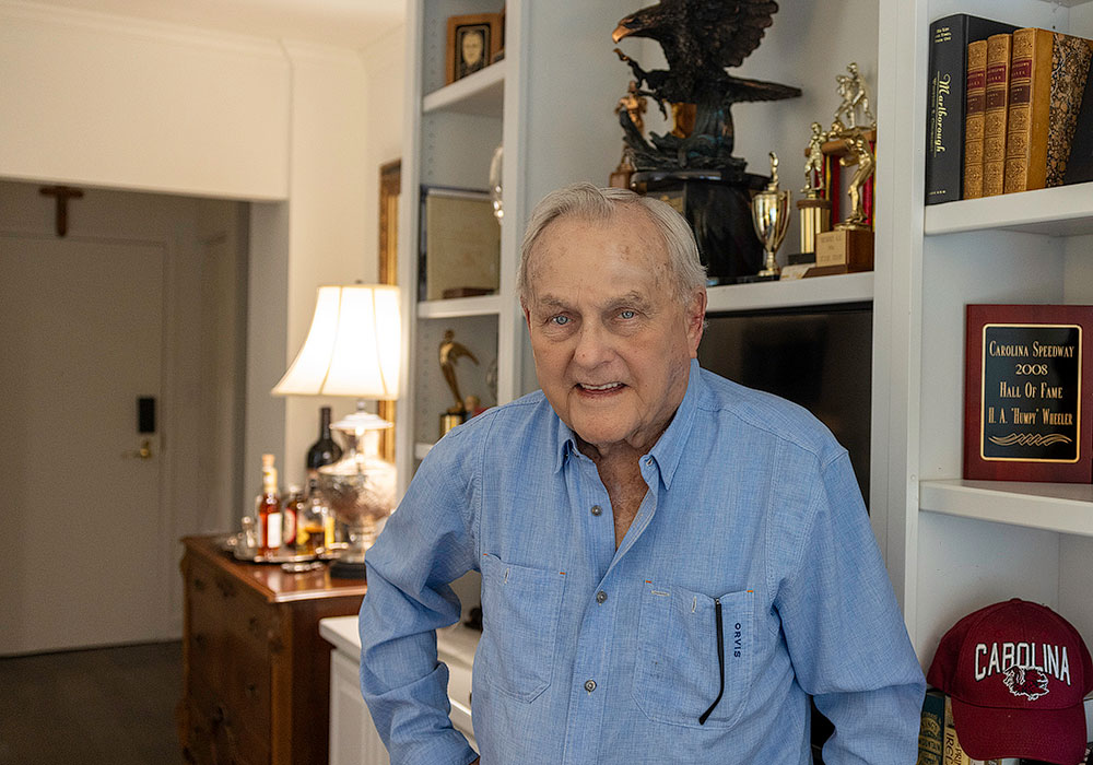 Humpy Wheeler stands in front of his bookshelves