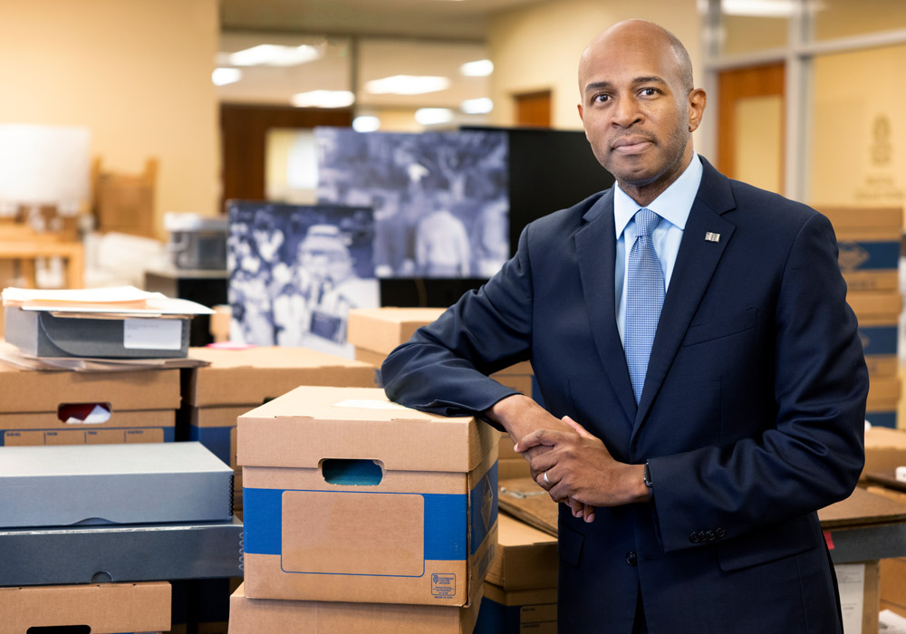 Bobby Donaldson leans on a large stack of document boxes.