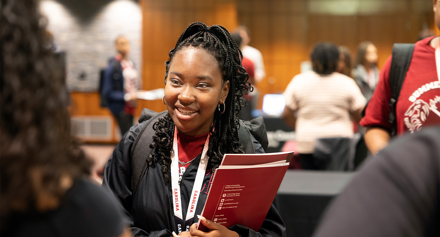 Summer Seniors student stands at table at academic fair