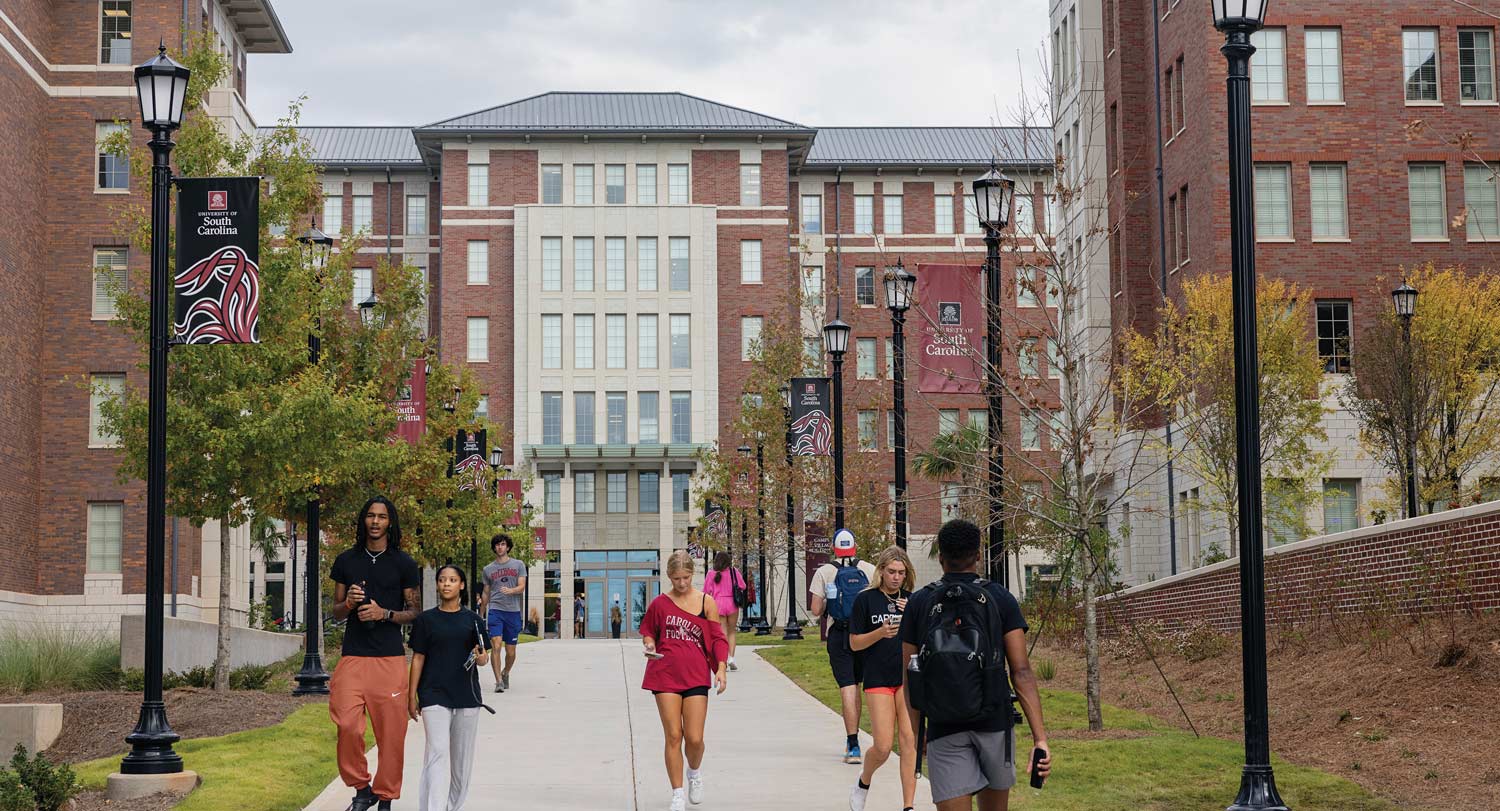 A view of campus village with students walking by.