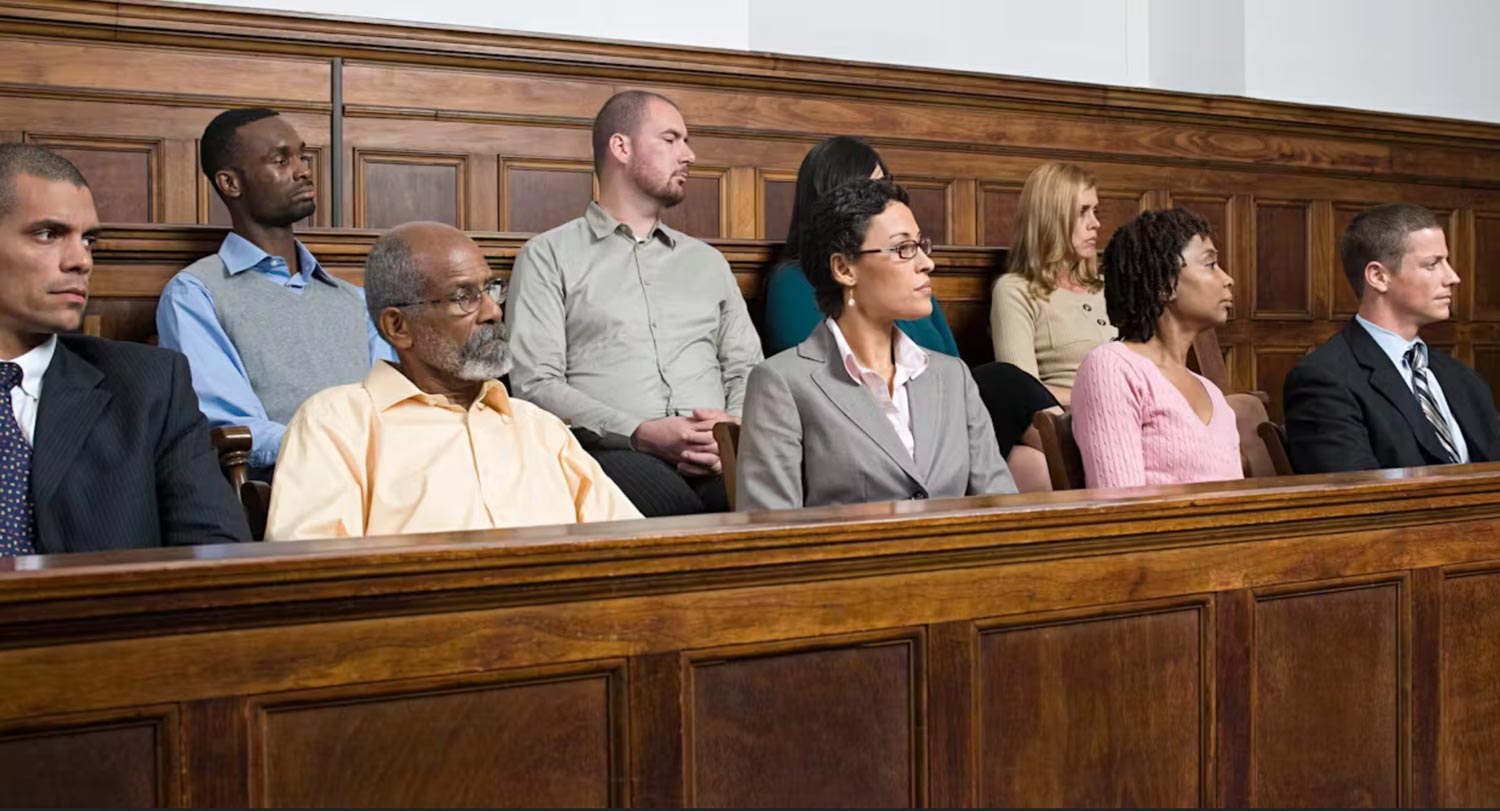 People sitting as a jury in a court room with concerned an interested facial expressions.